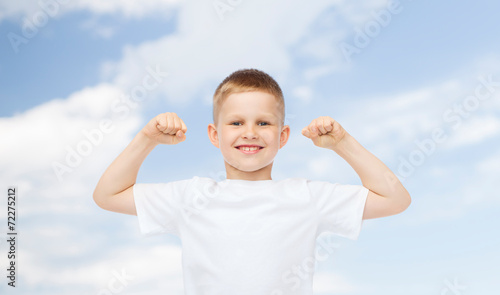 happy little boy in white t-shirt flexing biceps