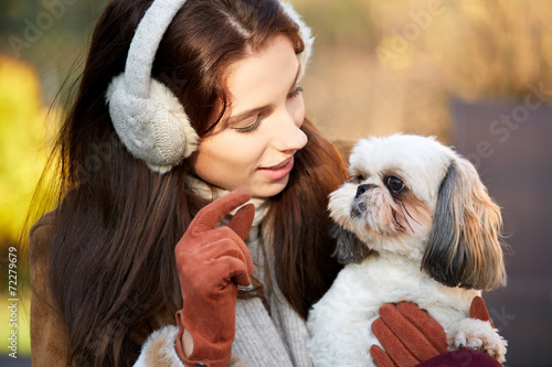 young woman playing with a small dog photo