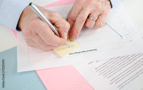 Man taking a note on a post it