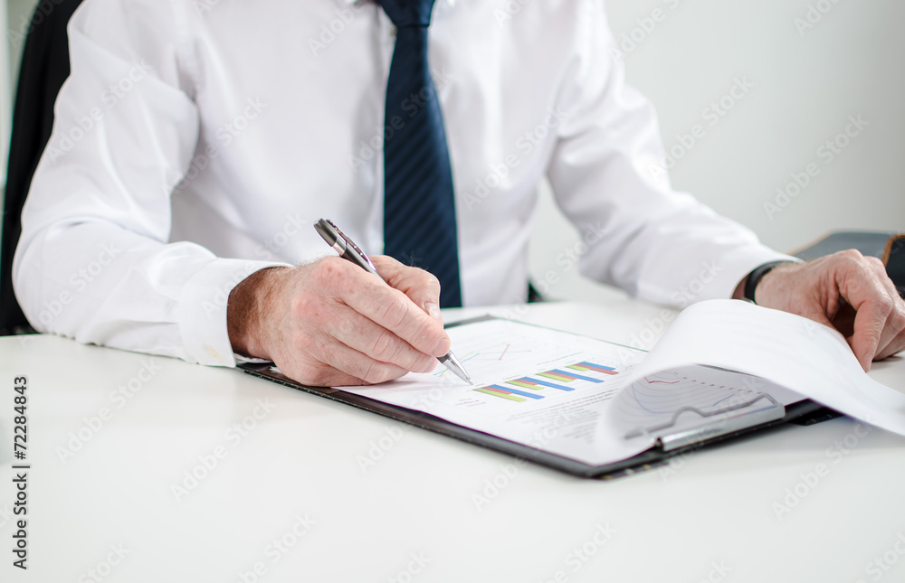 Businessman checking financial charts Businessman checking financial charts