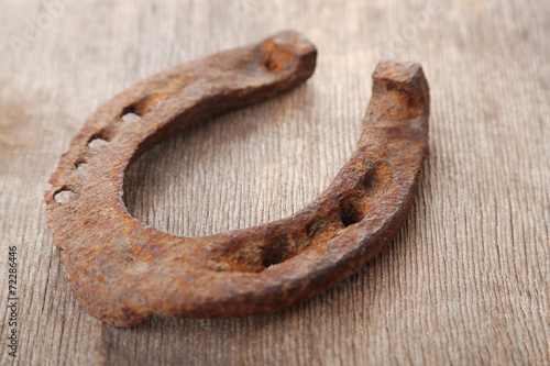 Old horse shoe on wooden background