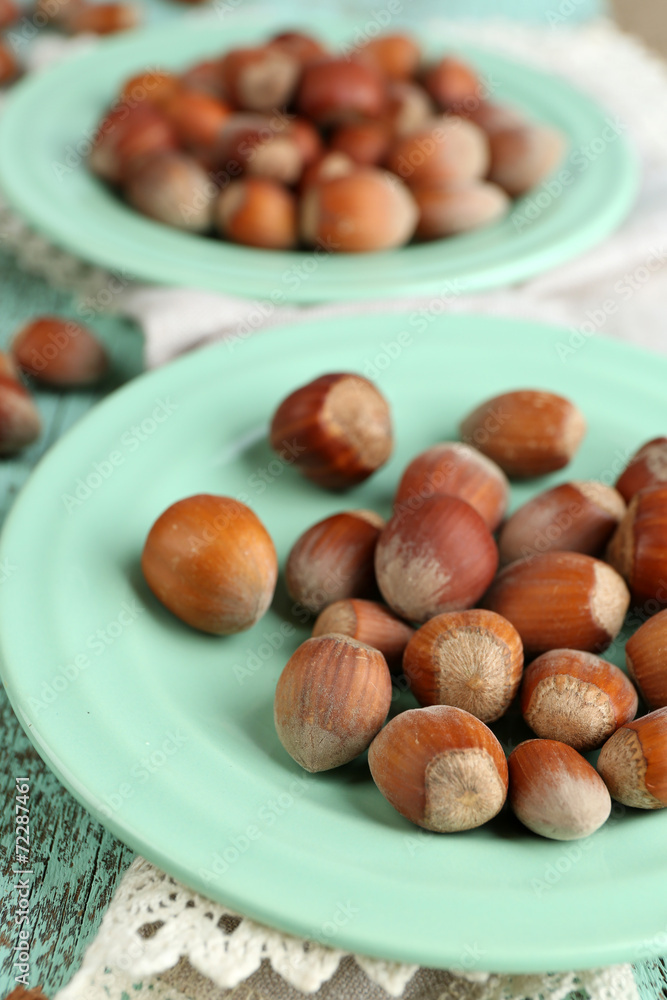 Hazelnuts on plates on wooden background Hazelnuts on plates on wooden background
