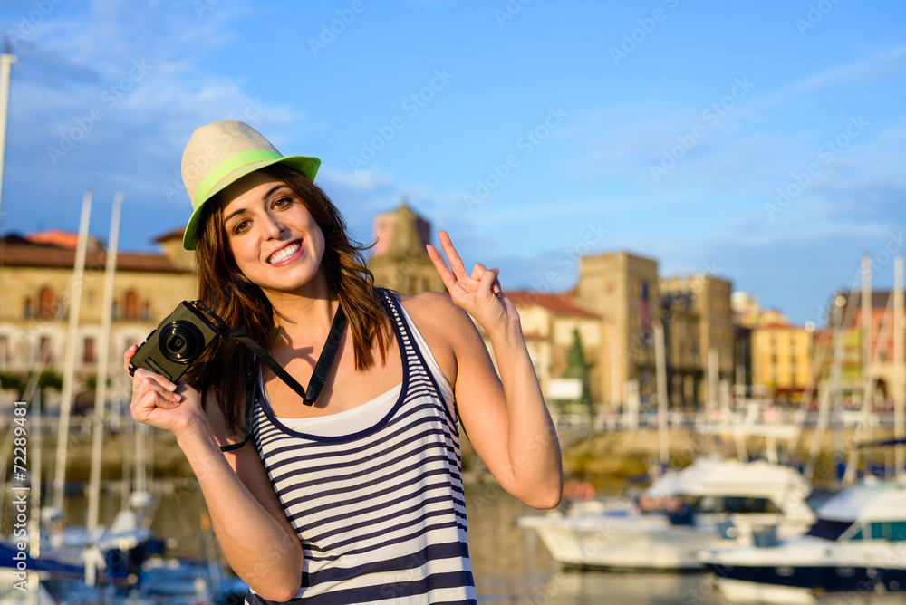 Successful happy tourist with camera by the harbor