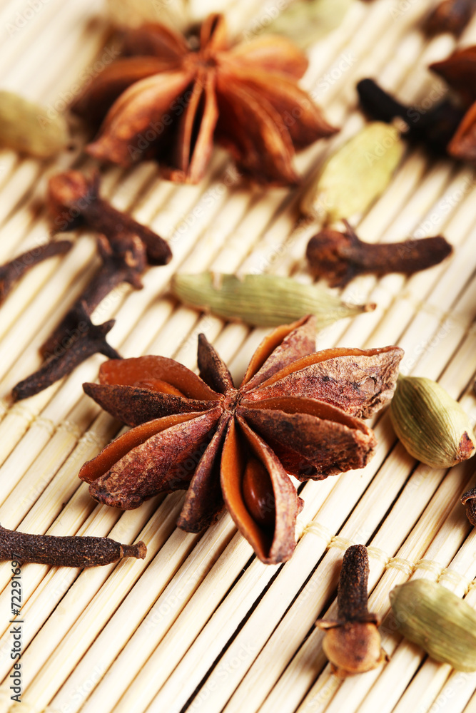 Stars anise with cardamom and carnation on wicker background Stars anise with cardamom and carnation on wicker background