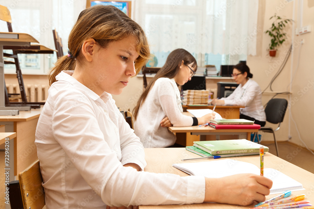 Student girls during optional lesson before exam in classroom. Student girls during optional lesson before exam in classroom.