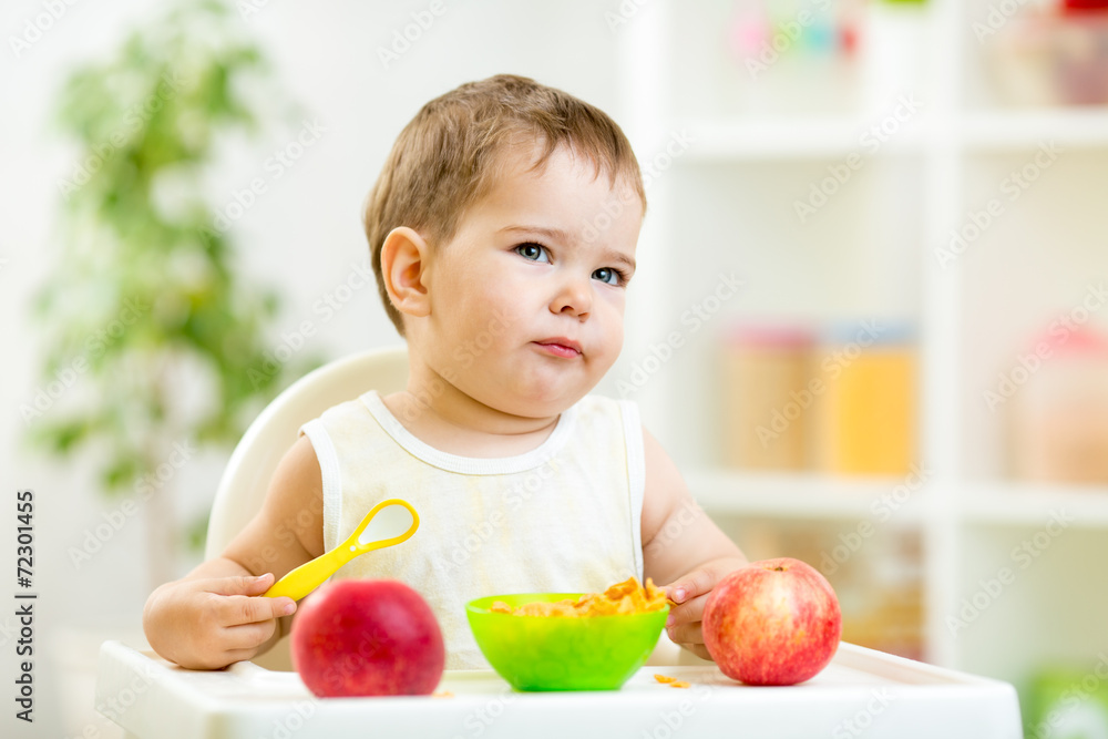 displeased kid boy with healthy food at kitchen displeased kid boy with healthy food at kitchen