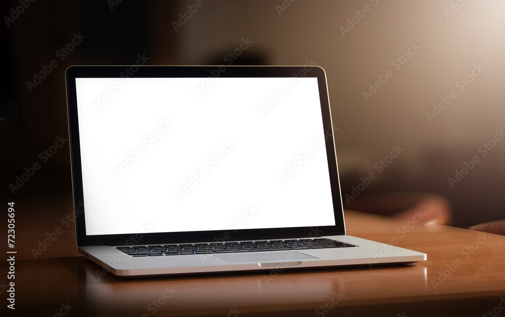 Angled notebook with blank screen on table in home interior Angled notebook with blank screen on table in home interior