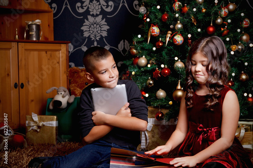 Cute little children opening a Christmas present
