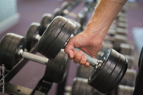 Close up of hand holding dumbbell in gym