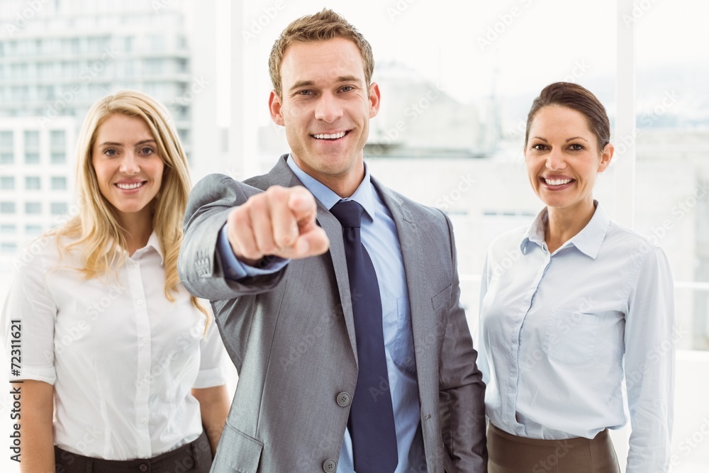 Businessman pointing at you with colleagues in office Businessman pointing at you with colleagues in office