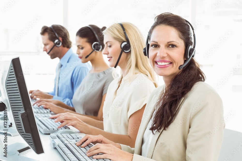 Business people with headsets using computers in office Business people with headsets using computers in office