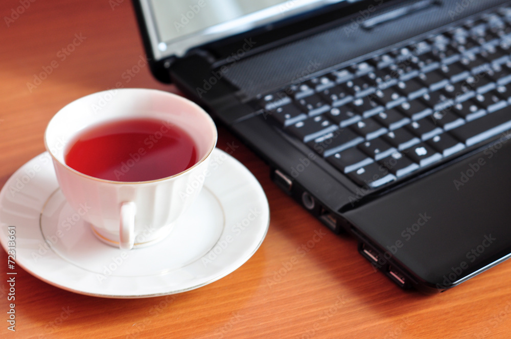 Laptop and a cup of tea Laptop and a cup of tea