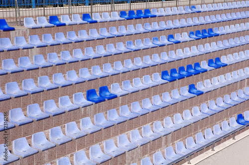 Rows of light and dark blue plastic stadium seats