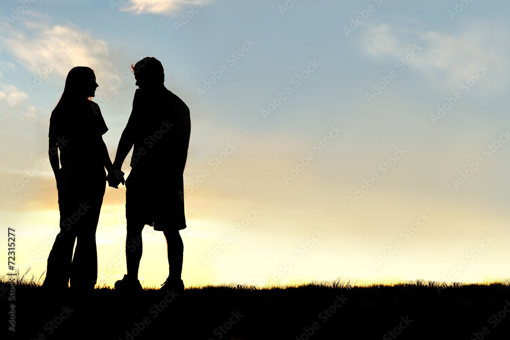 Silhouette of Happy Couple Holding Hands and Talking at Sunset Silhouette of Happy Couple Holding Hands and Talking at Sunset