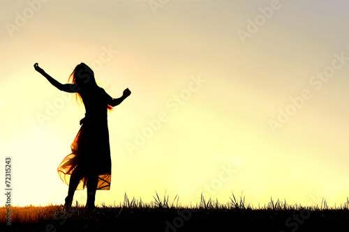 Silhouette of Woman Dancing and Praising God at Sunset