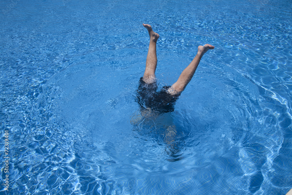 man handstands in a pool