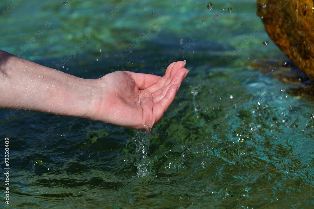 Beautiful woman hands on water