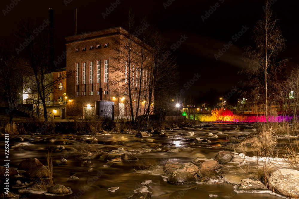 Old factory by the river at night