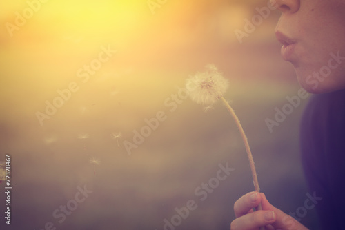 Woman blowing dandelion photo