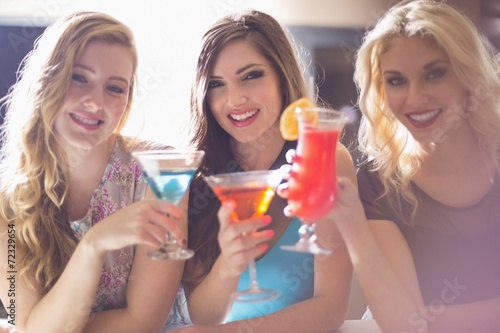 Attractive friends drinking cocktails together