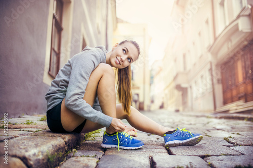 Photography Young female runner tying her shoes
