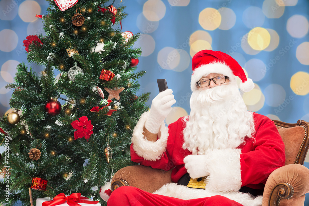 santa claus with smartphone and christmas tree santa claus with smartphone and christmas tree