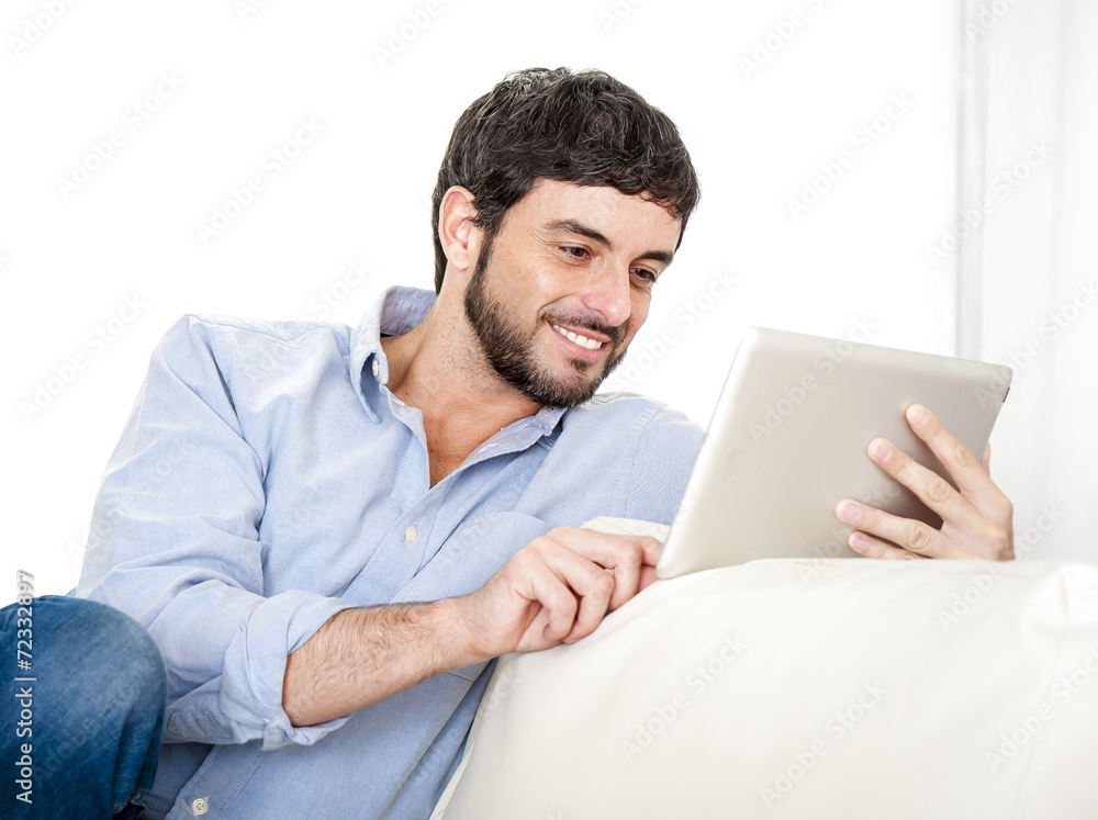 Young attractive Latin man at home using digital tablet pad Young attractive Latin man at home using digital tablet pad