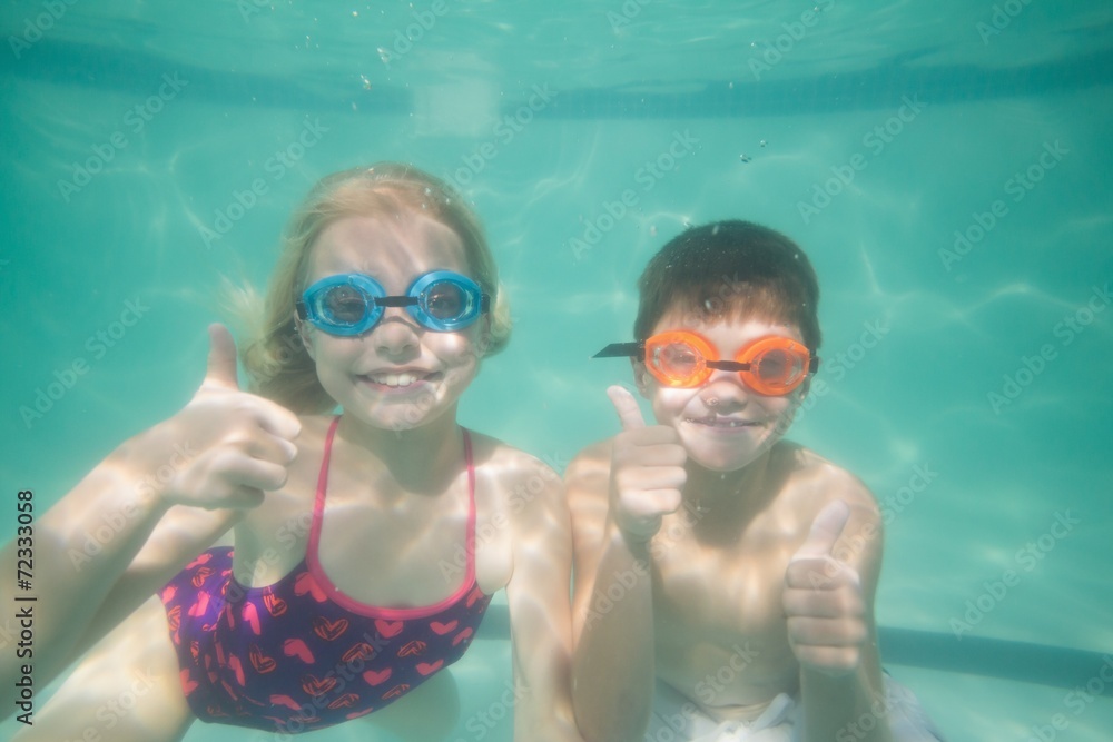 Naklejka premium Cute kids posing underwater in pool