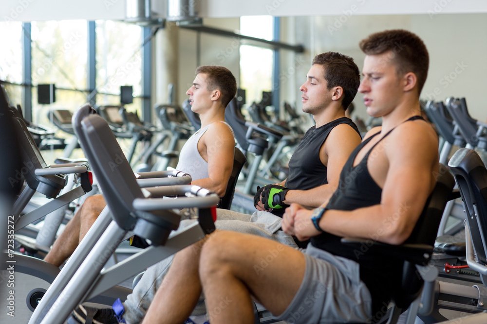 men working out on exercise bike in gym men working out on exercise bike in gym