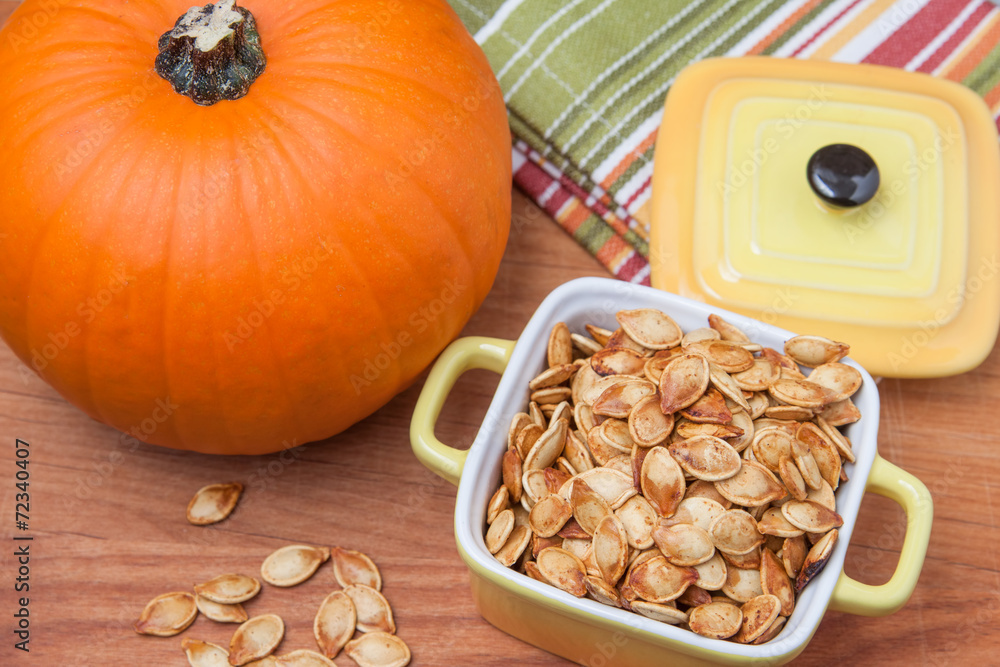 Obraz premium Roasted pumpkin seeds and pumpkin - top view