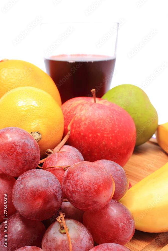 Fresh natural fruits and glass of juice on cutting board Fresh natural fruits and glass of juice on cutting board