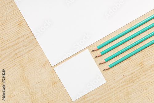 Blanks of empty paper with pencils on a wooden surface.