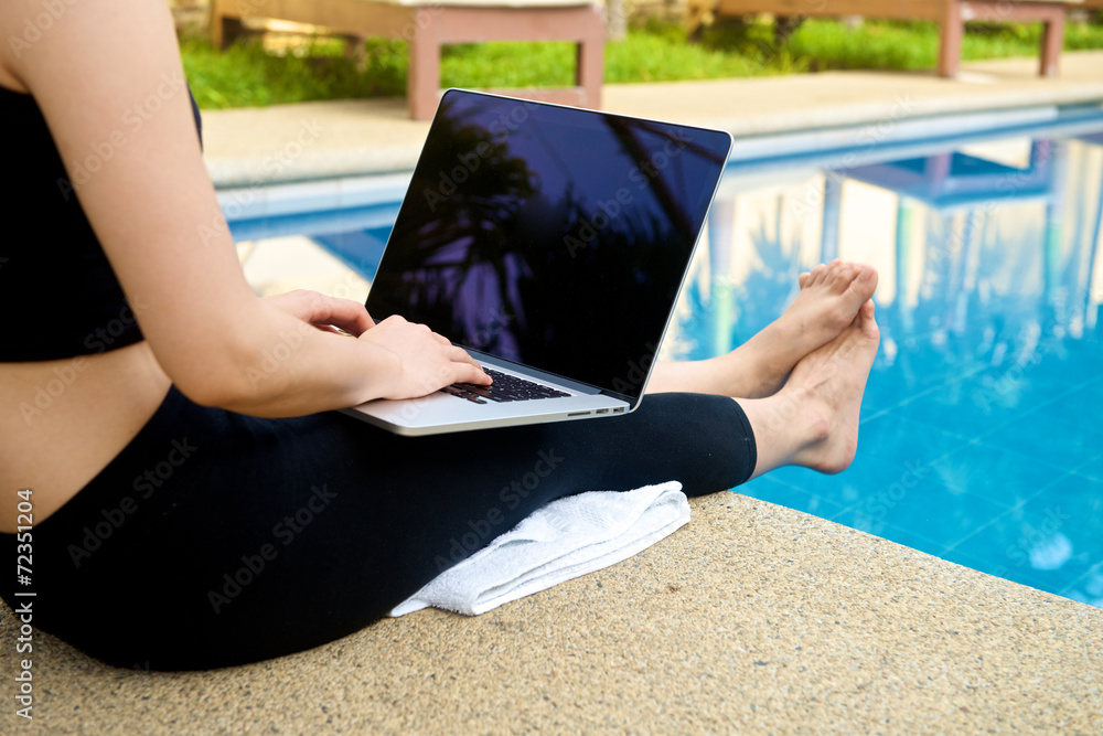 Girl work with laptop at pool