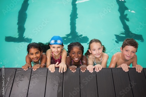 Cute swimming mixed race class smiling at camera