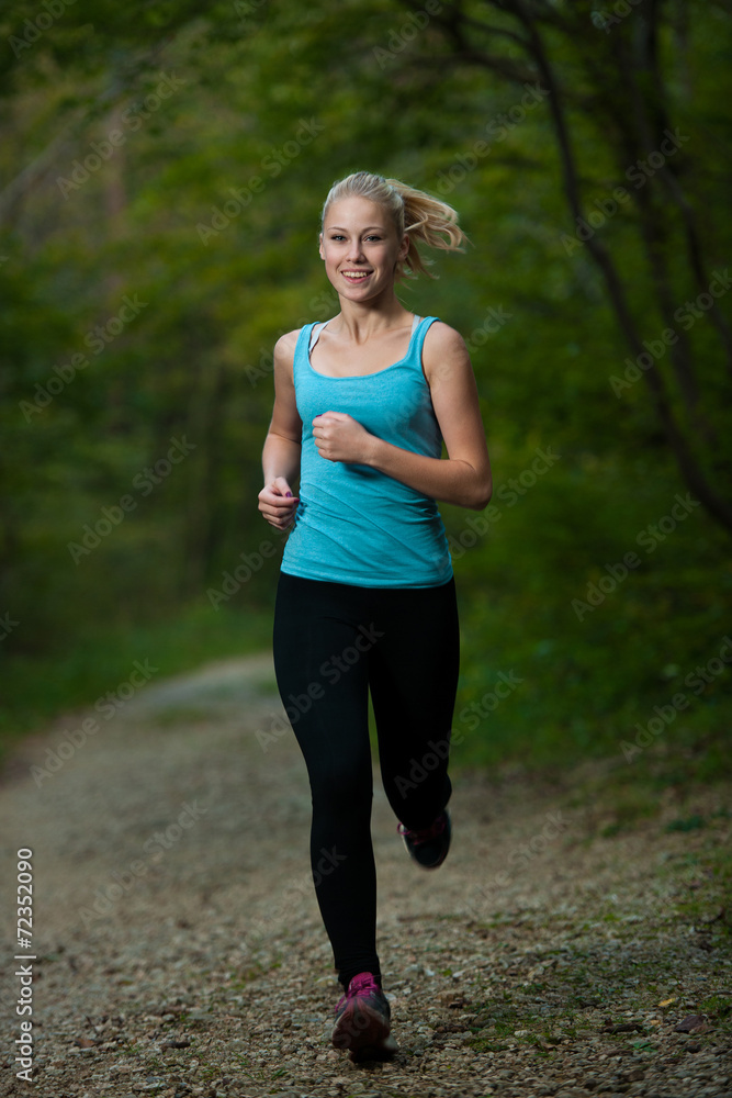 beautiful young woman runs in forest - active runner running