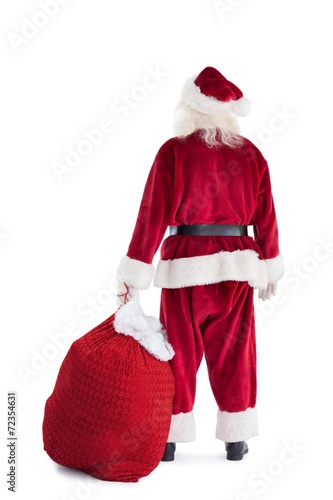 Santa is holding his bag in one hand