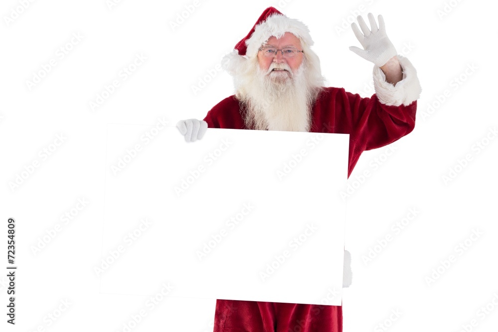 Santa holds a sign and is waving Santa holds a sign and is waving