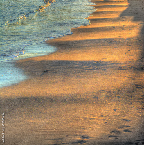 Wavy sand under a bright sun at sunset photo