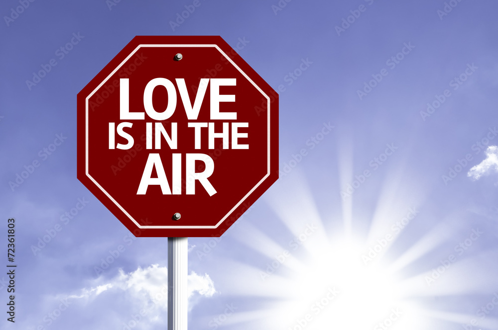 Love Is In The Air written on red road sign Love Is In The Air written on red road sign
