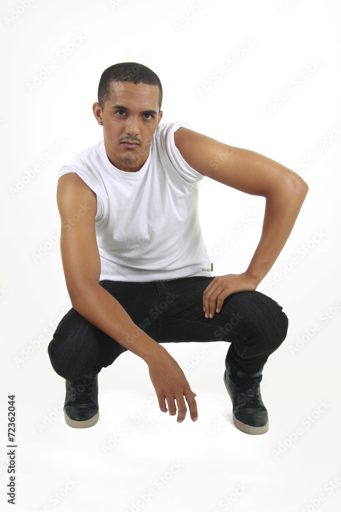 Young man crouching staring at a subject Young man crouching staring at a subject