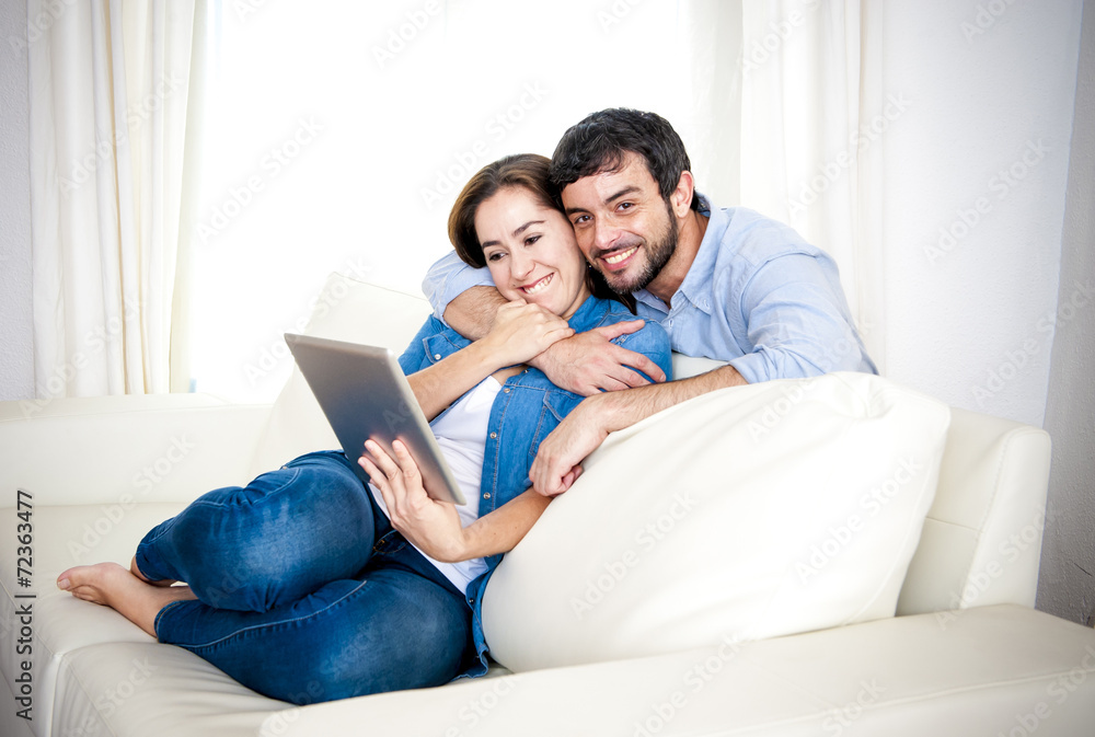 couple on couch enjoying using digital tablet computer