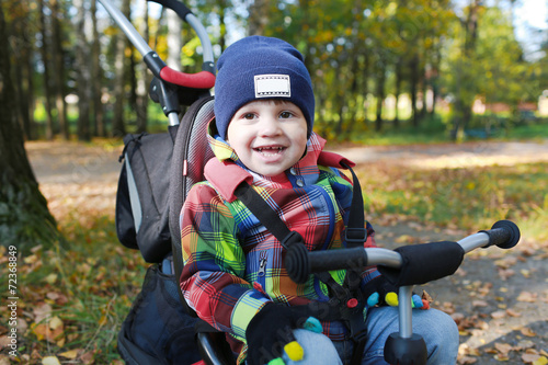 lovely toddler on a bike in autumn park