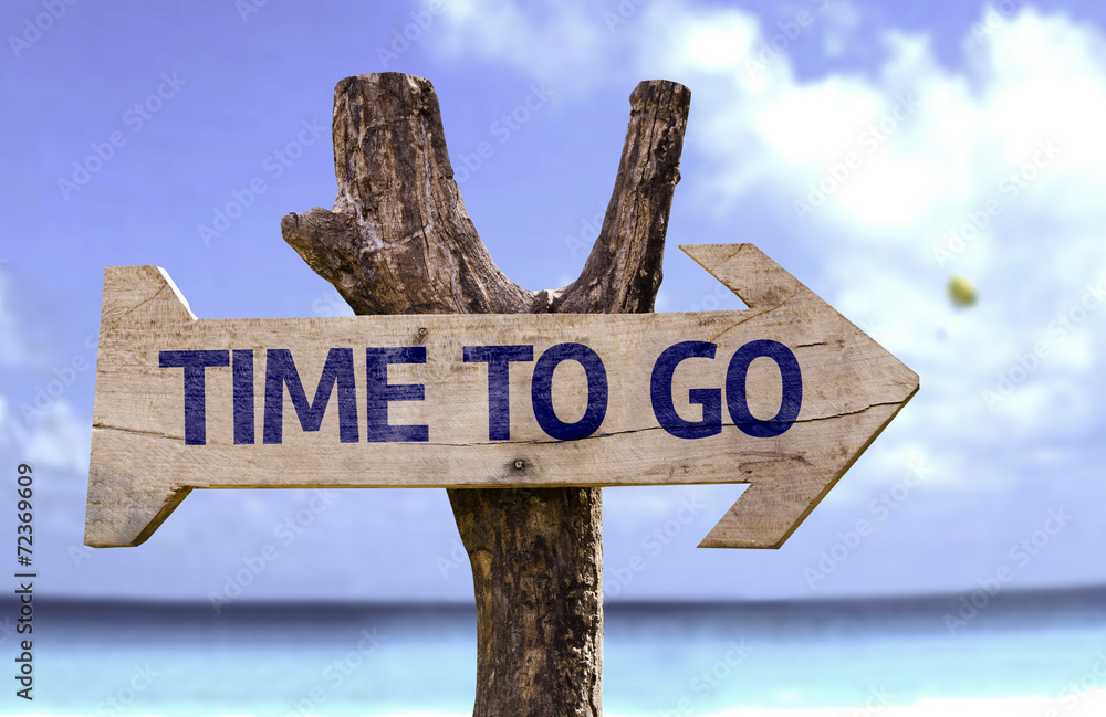 Time to Go wooden sign with a beach on background