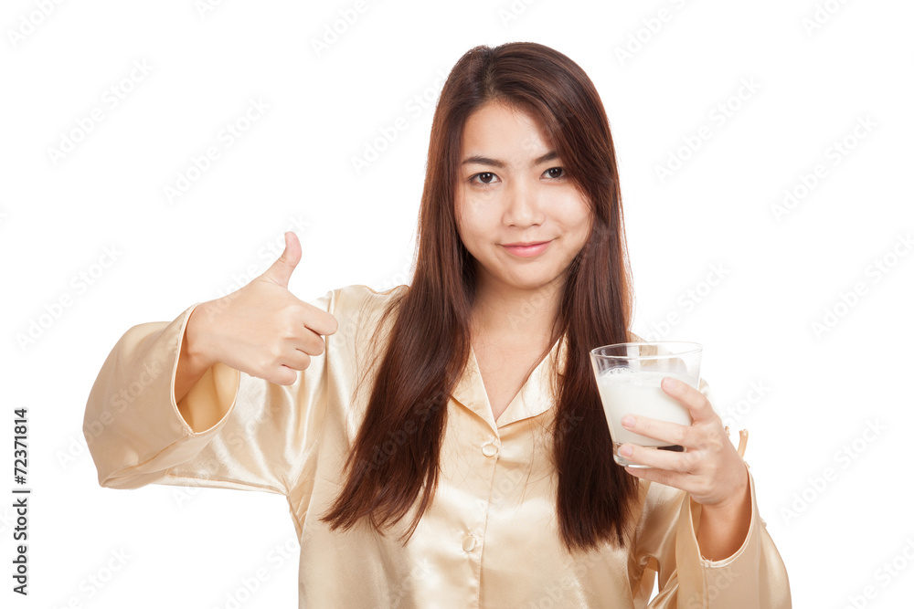 Happy Asian woman in pajamas show thumbs up with milk Happy Asian woman in pajamas show thumbs up with milk