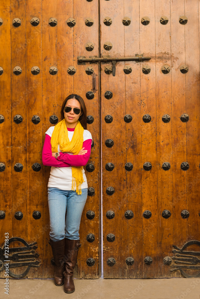 The asian woman stands in front of wooden door in Marakesh The asian woman stands in front of wooden door in Marakesh