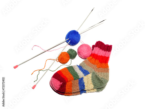 Warm knitted woolen socks knitting needles isolated on a white b