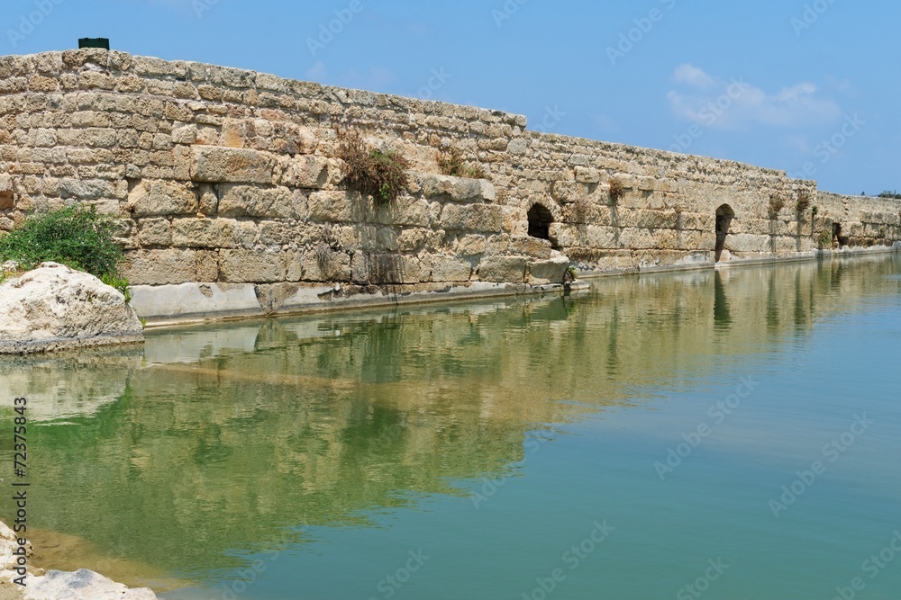 Ancient wall reflecting in the pond in Nahal Taninim, Israel