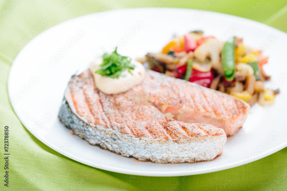 Grilled Salmon with Fresh vegetables on green background Grilled Salmon with Fresh vegetables on green background