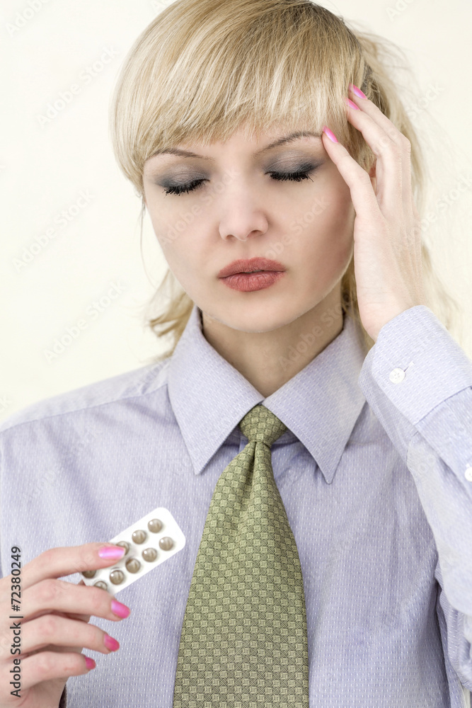 Young beautiful business woman with migraine and pills Young beautiful business woman with migraine and pills