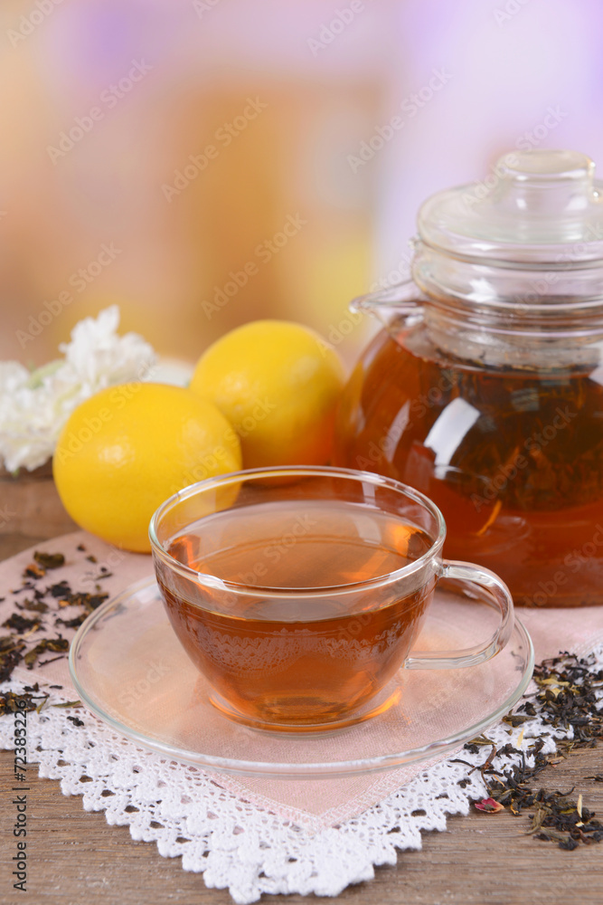 Teapot and cup of tea on table on light background Teapot and cup of tea on table on light background